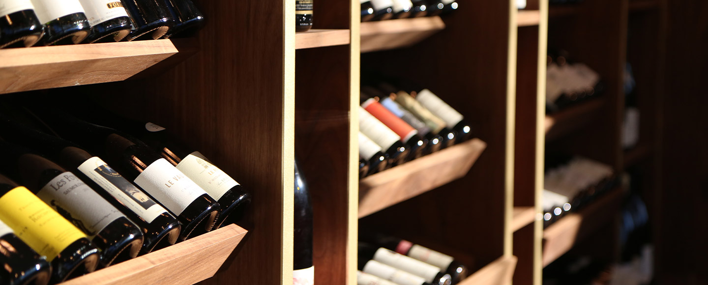A serene view of a well-stocked wine cellar, with bottles of wine neatly arranged on wooden racks, awaiting the connoisseur's choice.